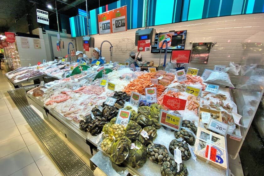 Mercado de pescado vacío con pocos compradores, mostrando la crisis de consumo en casa
