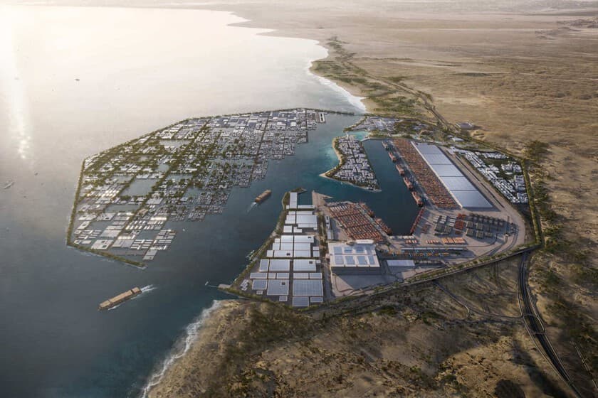Vista aérea de una terminal portuaria en el Mar Rojo con grúas y contenedores, al fondo el desierto.