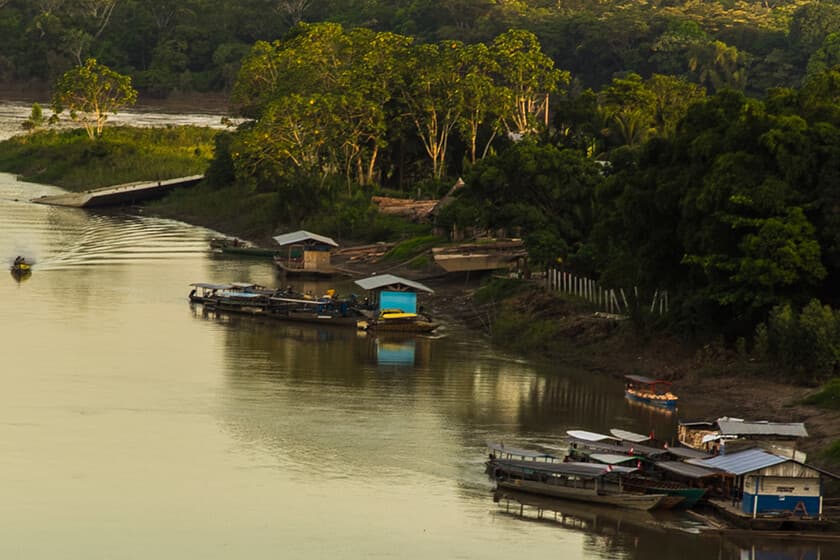Río amazónico contaminado con mercurio, con sedimentos turbios y vegetación ribereña