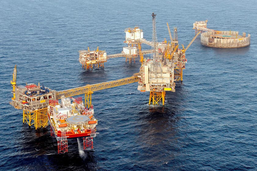 Plataforma petrolífera en el Mar del Norte al atardecer, con nubes de tormenta al fondo