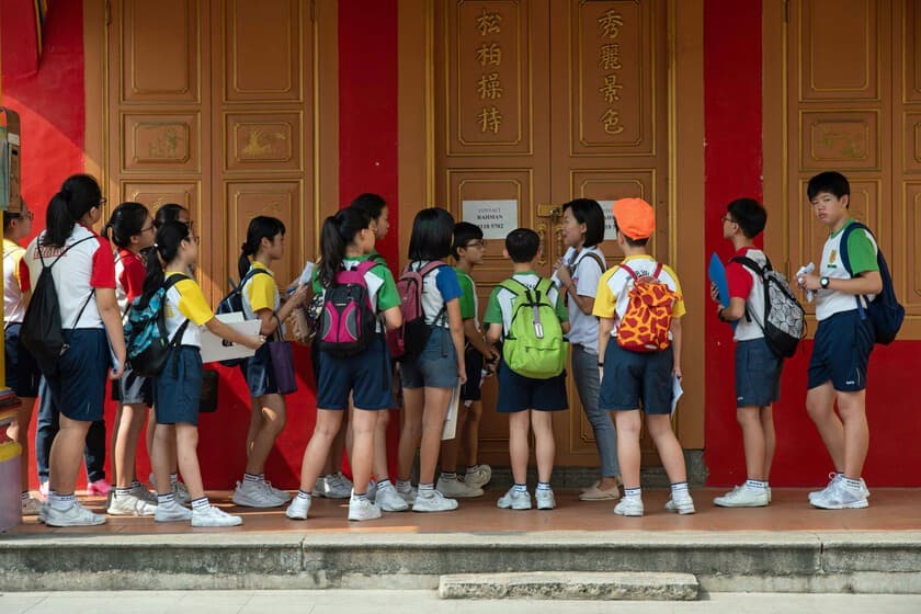 Un aula vacía con una vara sobre un escritorio, simbolizando el castigo físico en escuelas de Singapur