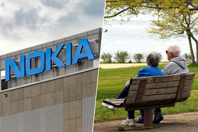 Personas mayores sentadas en un banco en un pueblo finlandés, con un paisaje nevado de fondo
