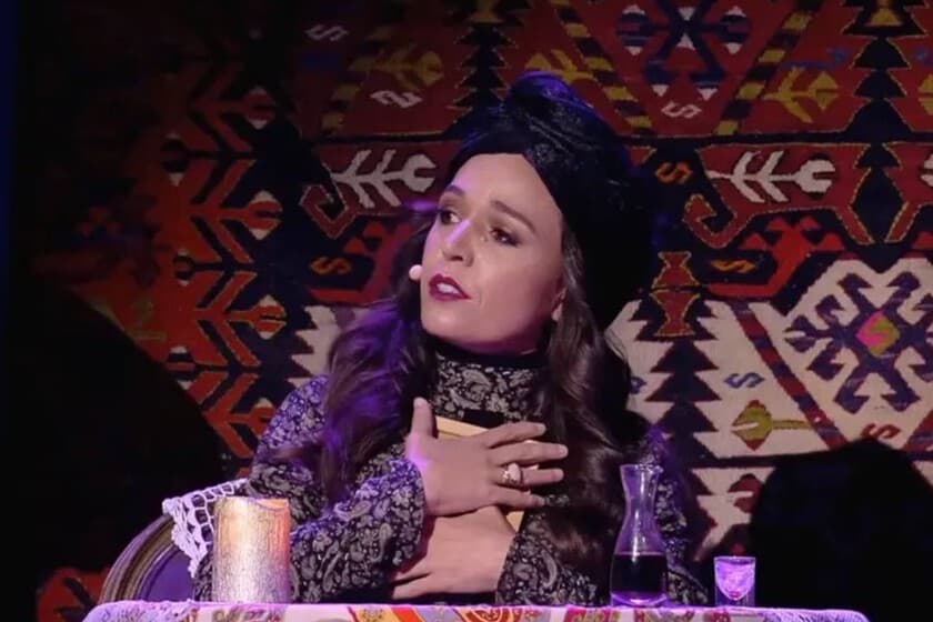 Soprano en el escenario de Las Vegas, sin muñeco, con expresión concentrada y micrófono en mano.