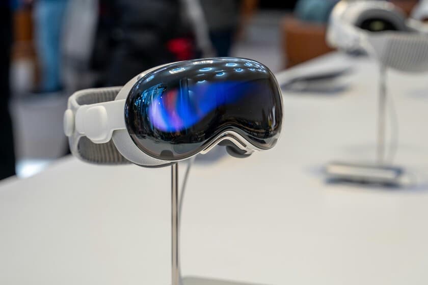 Una Apple Vision Pro sobre una mesa, con cables desordenados, en un entorno minimalista pero polvoriento, simbolizando a