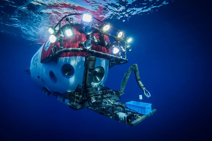 Submarino de lujo descendiendo en el océano, con luz artificial y fondo azul profundo