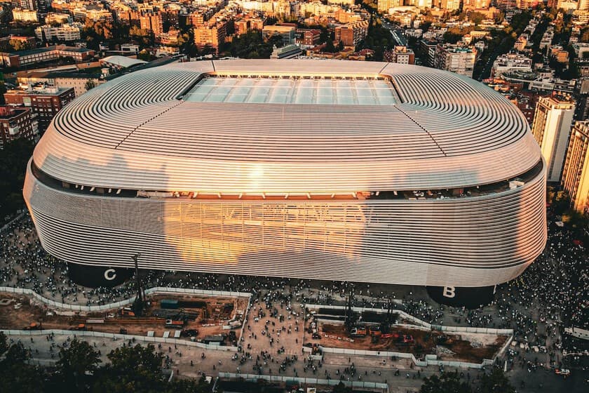 Vista aérea del Estadio Santiago Bernabéu iluminado durante un concierto, con el público vibrando