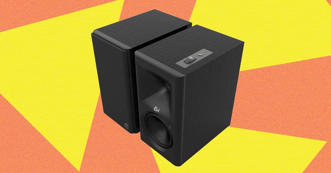 Altavoces Klipsch the Fives II sobre un mueble minimalista, con una planta y un libro abierto