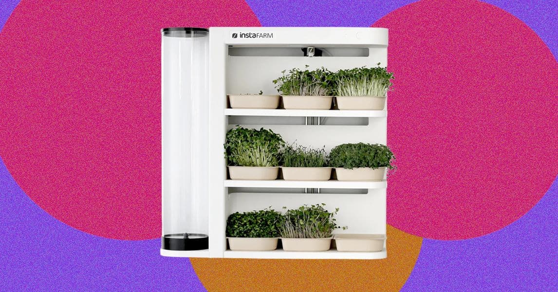 InstaFarm en una encimera de cocina con microgreens creciendo bajo luz LED