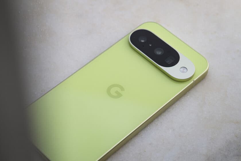 Google Pixel 10 sobre una mesa de madera, con la pantalla encendida mostrando el reloj, al lado de un café y una libreta
