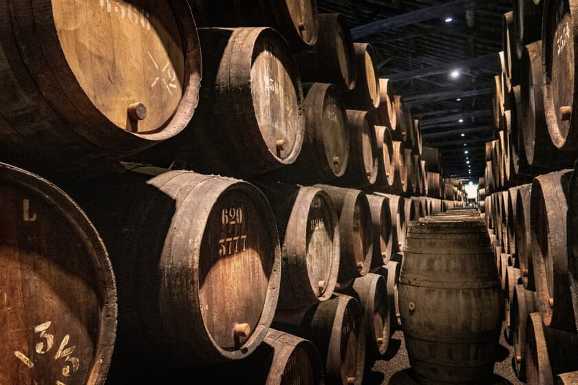 Botella de vino vacía y copa al lado, con gráfico descendente de fondo