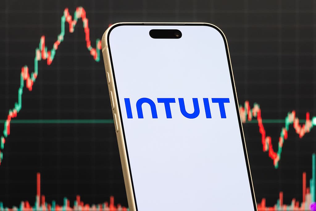 Oficina vacía de Intuit con sillas apiladas y pantallas mostrando gráficos de IA