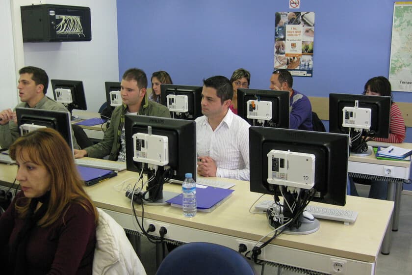 Personas examinándose en una oposición con ordenadores portátiles