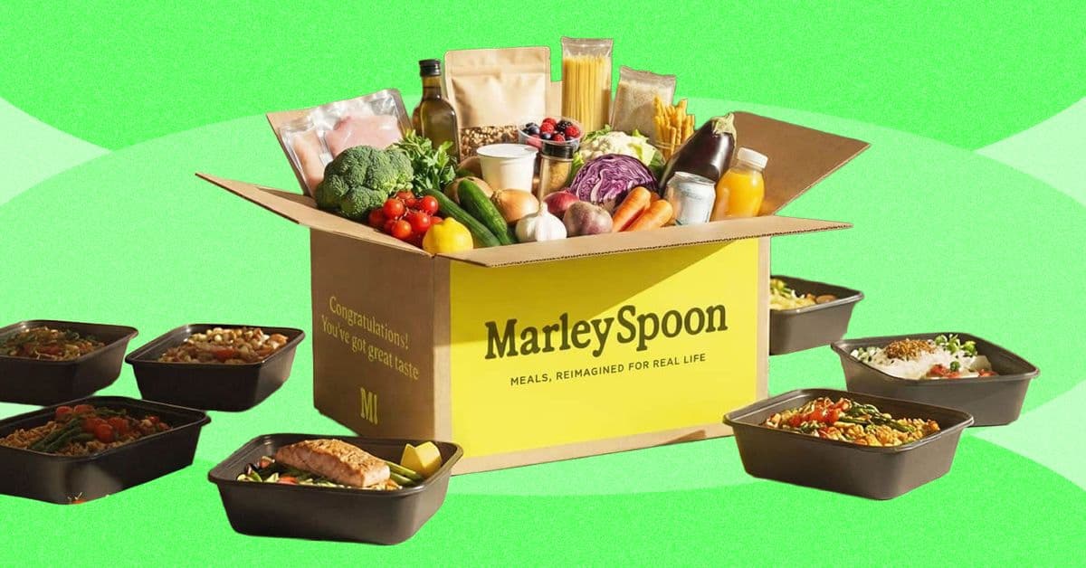 Caja de kit de comida con ingredientes frescos sobre una mesa de cocina
