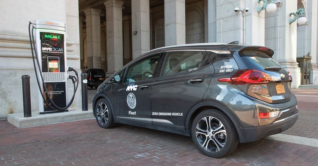 Vehículos eléctricos estacionados en una calle urbana con edificios de fondo