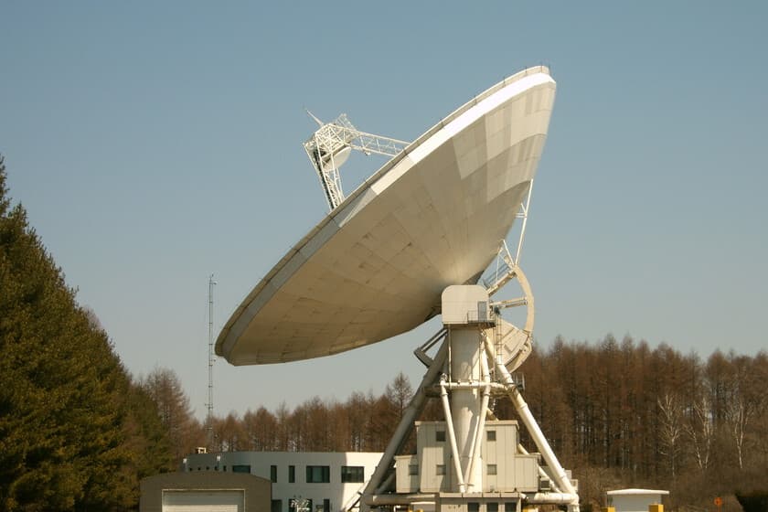 Render del telescopio AtLAST en un paisaje desértico con paneles solares y fondo estrellado