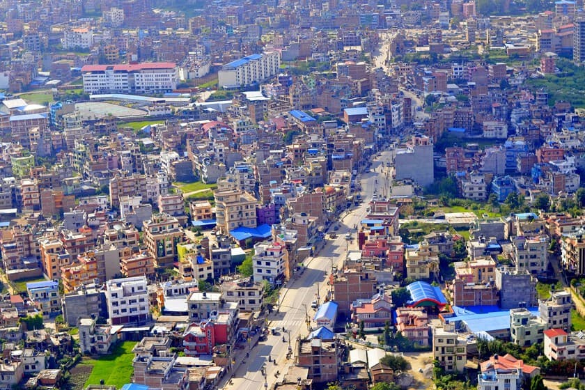 Trabajadores nepaleses vertiendo plástico fundido sobre una carretera en construcción