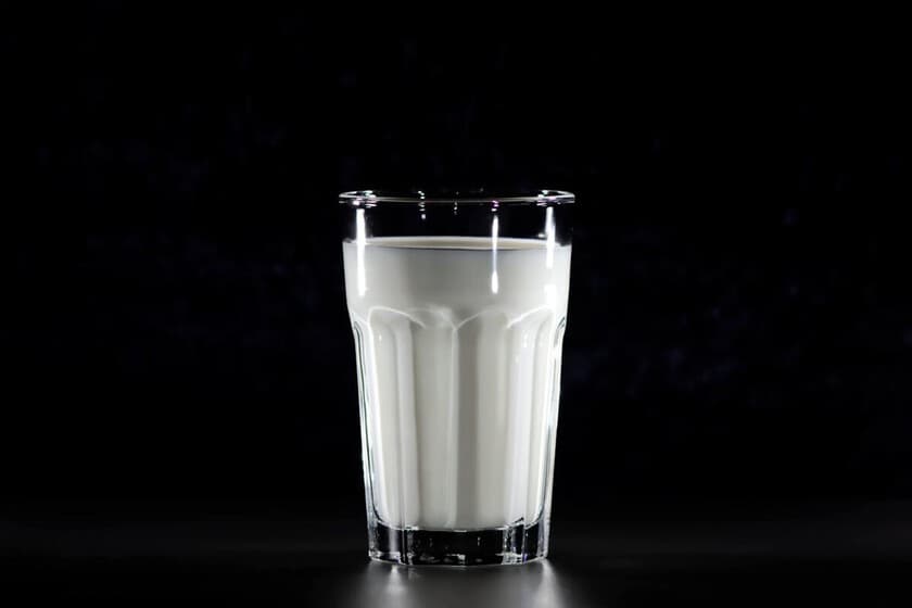 Comparación visual de un vaso de leche de vaca y uno de leche de almendras con etiquetas nutricionales