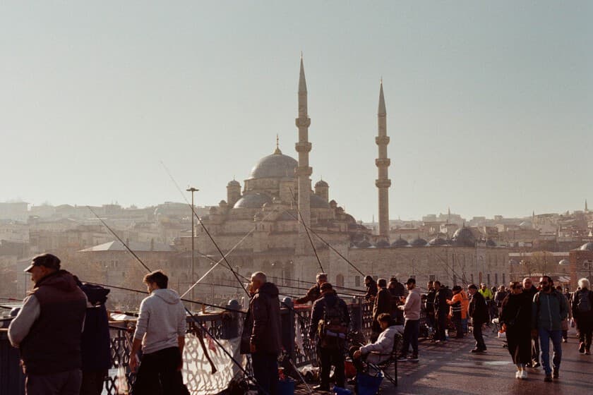 Gráfico de la tasa de fertilidad en Turquía en descenso, con un reloj de arena al fondo
