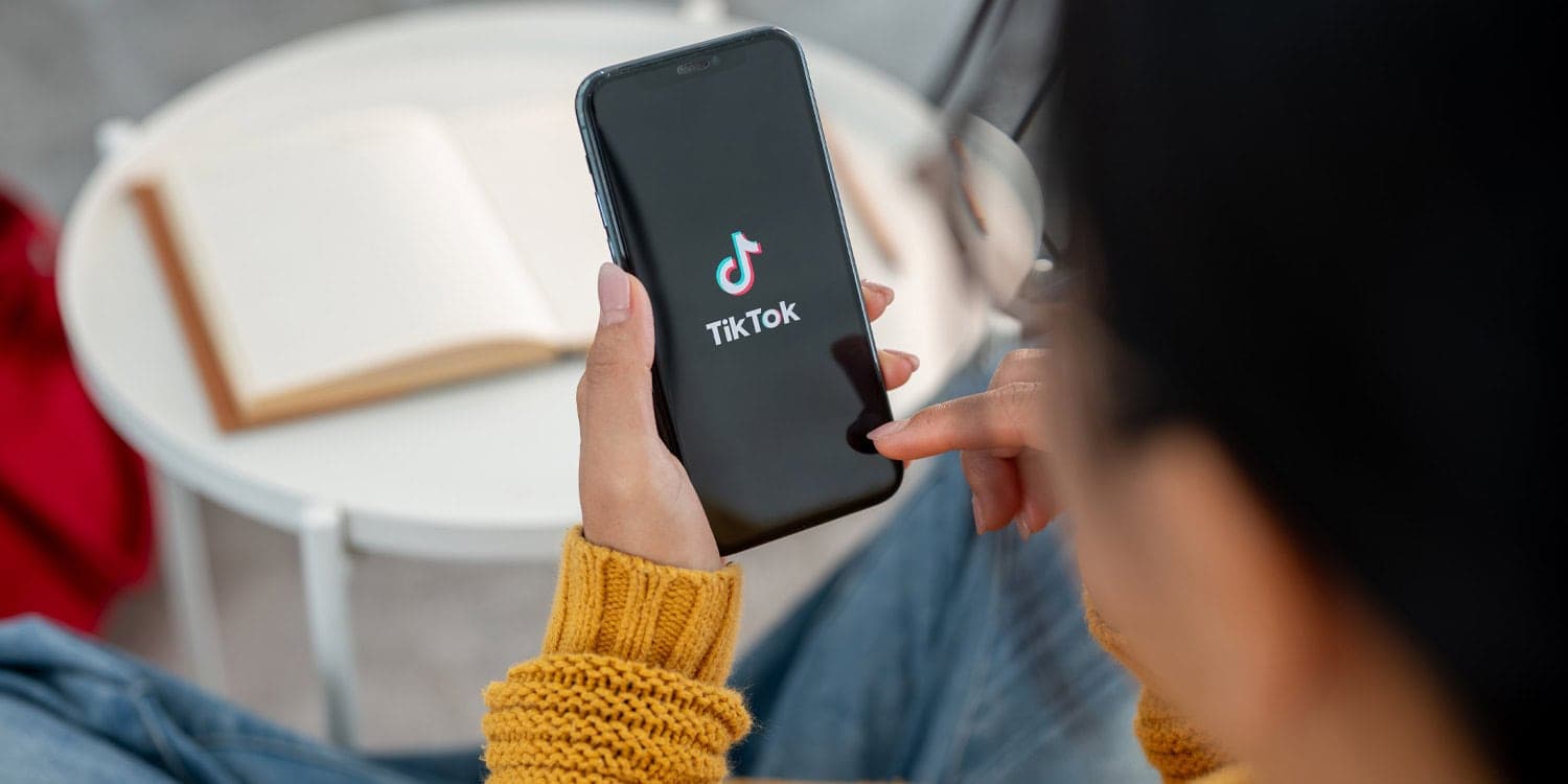 Ilustración de un teléfono con el logo de TikTok y gráficos de barras que muestran sesgo político