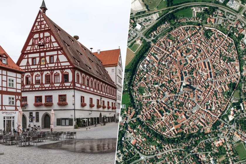 Vista aérea de la ciudad medieval de Nördlingen con sus murallas y torres, rodeada de campo verde.