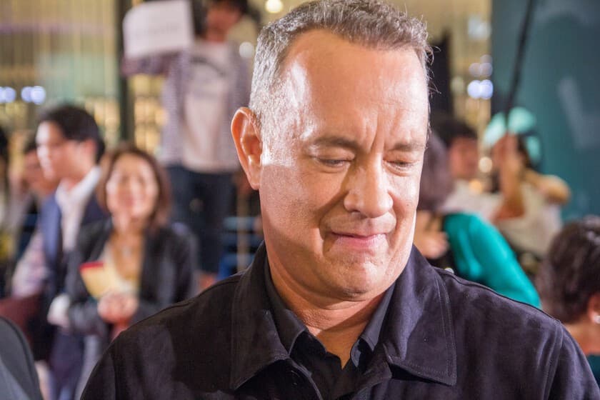 Tom Hanks en una escena de una película clásica, con expresión seria y reflexiva.