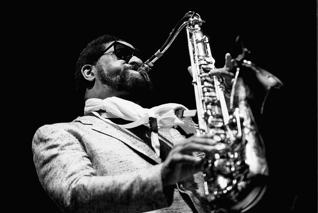 Sonny Rollins tocando el saxofón en un escenario, con expresión concentrada
