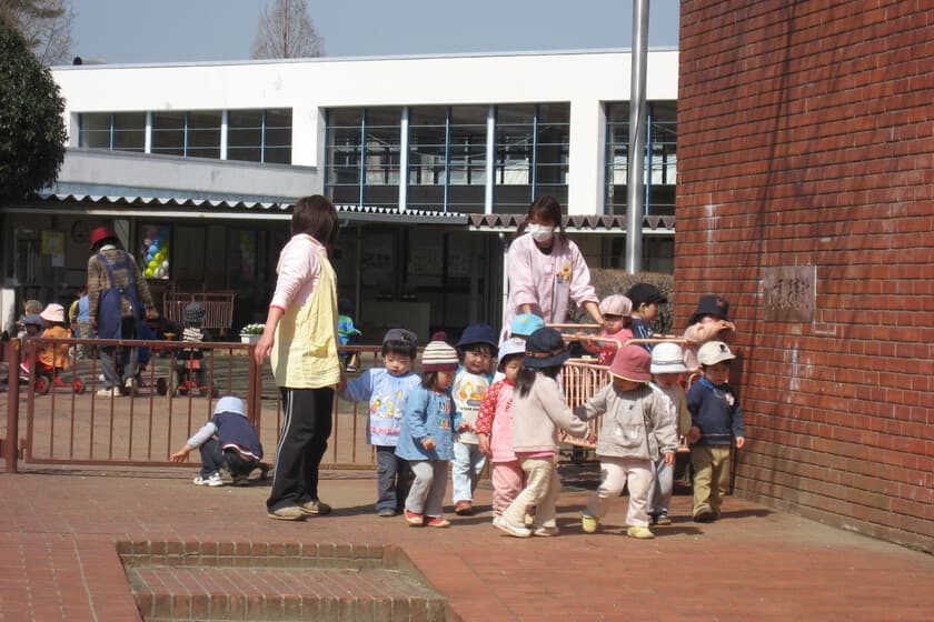 Niños jugando en una guardería japonesa moderna, con educadores al fondo