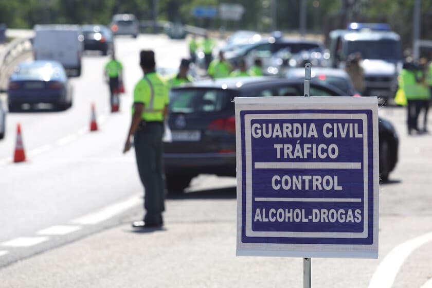 Agente de tráfico realizando prueba de drogas a un conductor en un control de carretera.