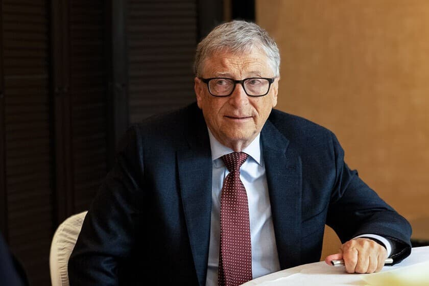 Bill Gates con expresión seria frente a un smartphone antiguo y el logo de Android