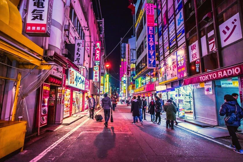 Gráfico descendente de población japonesa con silueta de ciudad vacía al fondo