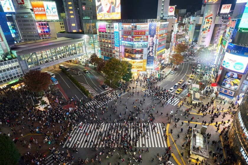 Turistas en un cruce de Tokio, con un policía observando y una papelera ausente