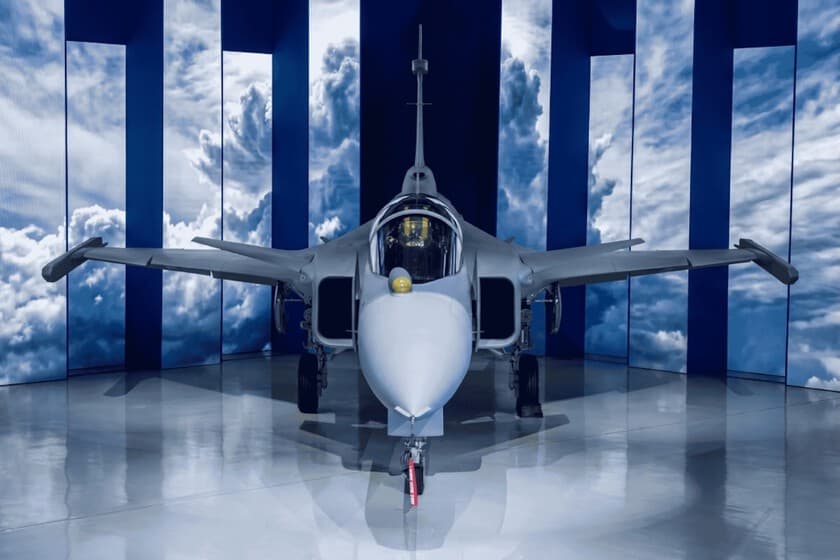 Avión de combate supersónico brasileño en vuelo, con bandera de Brasil al fondo