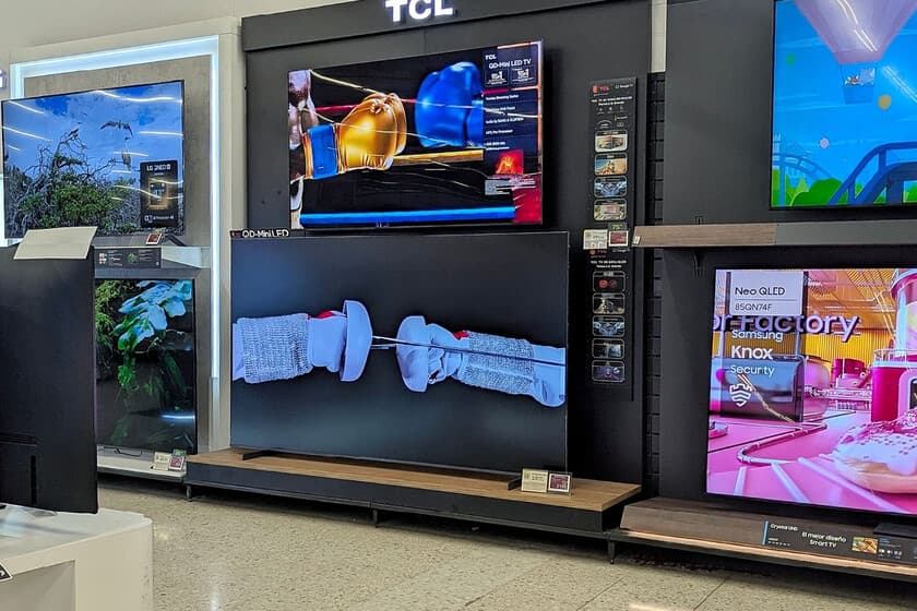 Televisor TCL QD-Mini LED de 85 pulgadas en un salón amplio, con imagen de paisaje natural en pantalla y mando Google TV