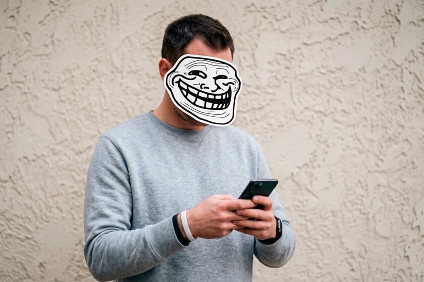 Teléfono móvil con mensaje de texto sospechoso y un icono de advertencia rojo