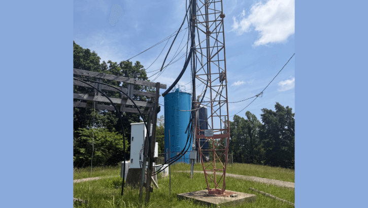 Torre de radio FM con antenas y cables visibles contra el cielo azul