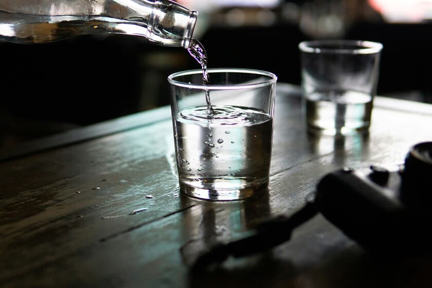 Vasos de agua con y sin hielo sobre una mesa, con fondo neutro, ilustrando el contraste entre costumbres occidentales y