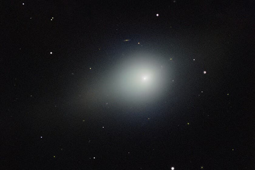 Ilustración del cometa interestelar 3I/ATLAS con el telescopio James Webb de fondo
