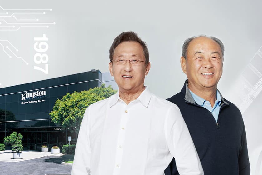 Dos empresarios sonrientes en una oficina moderna, con gráficos de crecimiento al fondo