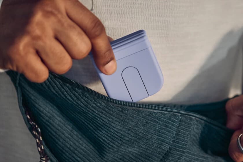 Ratón plegable Logitech abierto sobre un escritorio junto a un portátil