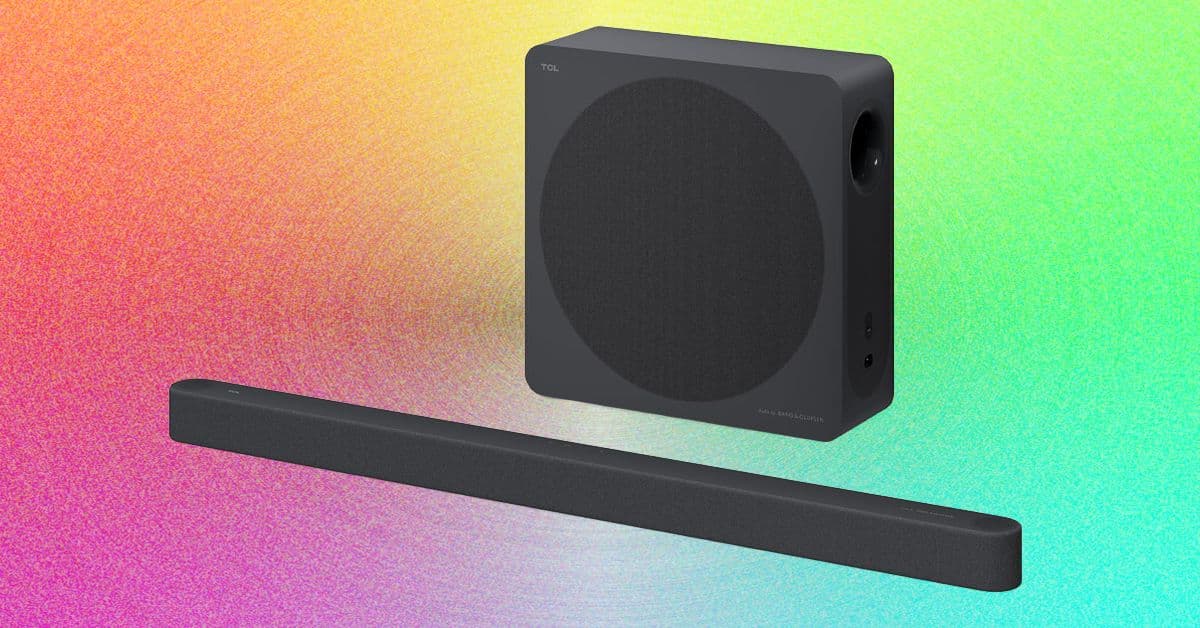 TCL A65K soundbar negra colocada frente a un televisor delgado, sobre un mueble limpio sin cables visibles.