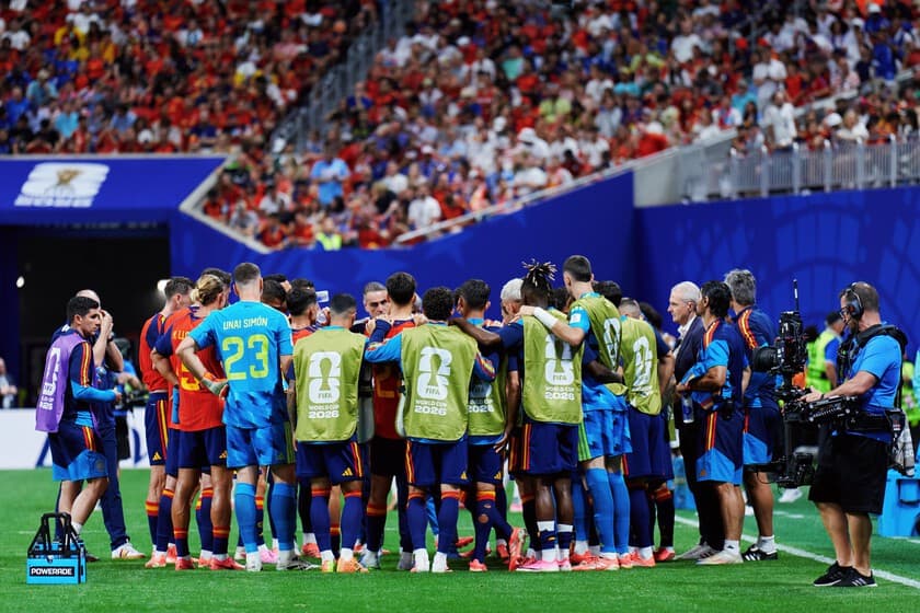 Jugadores de fútbol bebiendo agua durante una pausa de hidratación en un partido del Mundial