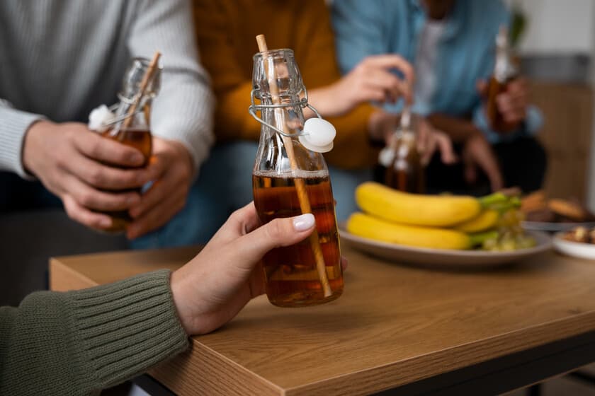 Botella de kombucha en una mesa de laboratorio junto a gráficos de cortisol