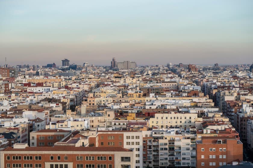 Fotografía de una fachada de edificio antiguo con cartel de 'Se vende' en España