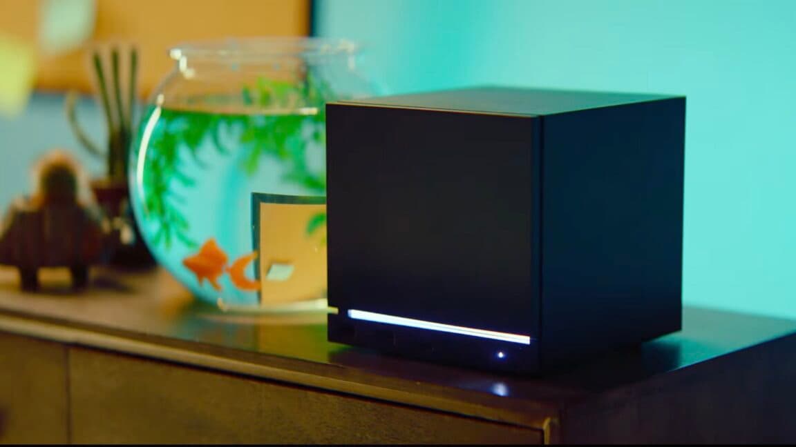 Fotografía de la Steam Machine de Valve sobre un escritorio minimalista, con un cable HDMI y un mando de Steam Controlle