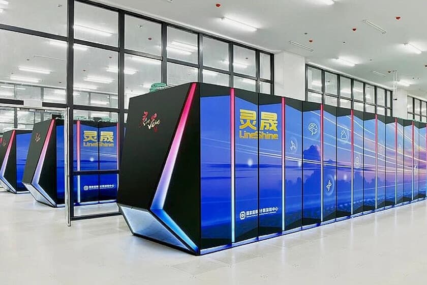Interior de un centro de datos con filas de servidores iluminados en azul, representando un superordenador.