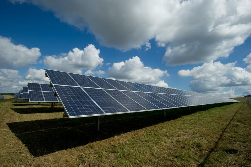 Paneles solares en un campo andaluz con la bandera de China al fondo